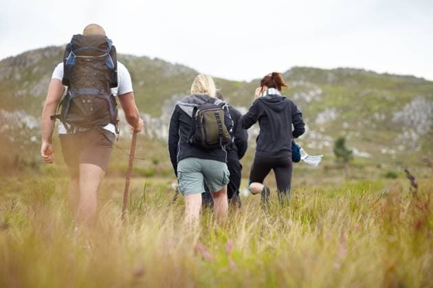 Nature, backpack and group of friends on hiking adventure in mountain with freedom from back. Travel, trekking and people walking in countryside, men and women on natural outdoor journey together model released property released Copyright: xPeopleImages.comx-x 51ff695161f4bx