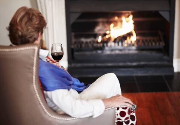 Relax, fire and senior woman with wine, home and comfortable with health, wellness and peace. Back, mature female person or old lady in a lounge, alcohol and warm for winter, weekend break or resting. model released property released Copyright: xPeopleImages.comx-x 529c6beac2b4ax