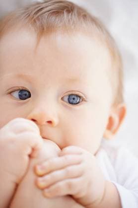 Creative Highlights Symbolfotos Home, bed and face of baby with feet relax, resting and calm in nursery wake up in morning. Family, youth and closeup of newborn in bedroom playing with toes for child development, fun and wellness. model released property released Copyright: xwww.peopleimages.comx