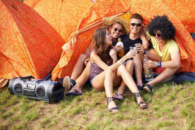 People, music festival and drinks by tent, excited and relax wellness in nature with friends. Men, woman or happy at social celebration for concert, weekend vacation or bonding in summer fun at party. model released property released Copyright: xPeopleImages.comx-x 396035x