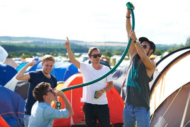 Alcohol, festival or drunk friends drinking together, beer beverage or outdoor social event. Summer music concert, party games celebration or excited people with freedom, hose funnel or pipe tube. model released property released Copyright: xwww.peopleimages.comx