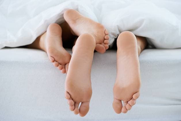 Couple, morning or feet with blanket in sleeping for peace or rest together on weekend in a house. Wellness, comfort or closeup of barefoot people in home for bond, care or nap under duvet in bedroom. model released property released Copyright: xPeopleImages.comx-x 523af2e5e2d15x
