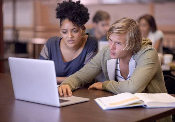 University, students and people in library on laptop for online research, studying and learning. Education, college and man and woman with textbooks, computer and reading website for knowledge. model released property released Copyright: xPeopleImages.comx-x 422813x