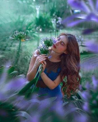 Creative Highlights Symbolfotos A young woman in an elegant outfit surrounded by lush greenery and flowers 26216303 ,model released, Symbolfoto RECORD DATE NOT STATED