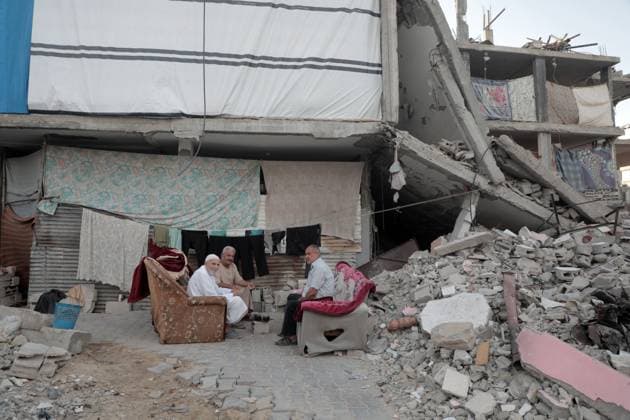 News Themen der Woche KW41 News Bilder des Tages Nahostkonflikt, Gaza, Eindrücke aus Chan Junis (241014) -- GAZA, Oct. 14, 2024 -- Palestinians sit among buildings destroyed by Israeli strikes in the southern Gaza Strip city of Khan Younis, on Oct. 13, 2024. (Photo by Xinhua) MIDEAST-GAZA-KHAN YOUNIS-DAILY LIFE RizekxAbdeljawad 