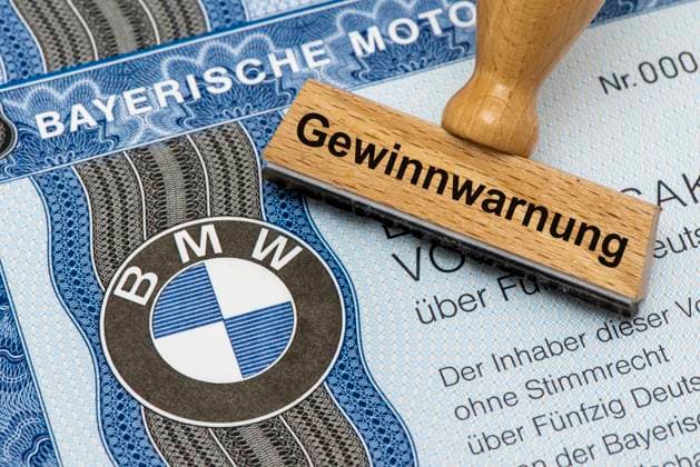 Gewinnwarnung für BMW Ein Holzstempel ist beschriftet mit dem Aufdruck: Gewinnwarnung, über einer BMW-Aktie mit Firmen-Logo Symbolbild *** Profit warning for BMW A wooden stamp is labeled with the words profit warning, above a BMW share with company logo Symbolic image