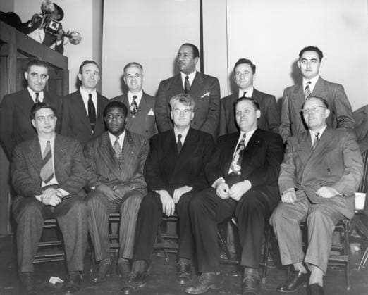 Orig. caption... DEFENDANTS IN RED CONSPIRACY TRIAL New york. Eleven of the twelve ranking members of the communist hierarchy on trial for conspiracy to form a party advocating the overthrow by violence of the U.S. Government are shown as they posed for press photographers in an anteroom of the federal building just before their trial opened today. Left to right seated are Robert Thompson, chairman of the N.Y. State Communist Organization; Henry Winston, former head of the Young Communist League; Eugene Dennis, general secretary of the Communist Party; Gus Hall, former head of the Ohio Communist Party, and John Williamson, called No. 4 communist in the U.S. and now under deportation warrant. Standing (L to R) Jack Stachel, director of the C  Copyright: xx AMERICAN COMMUNISTS PROSECUTED