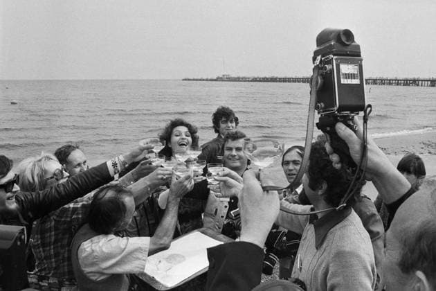 Angela Similea (Sopot 77) Die rumänische Pop-Sängerin Angela Similea stößt an mit Pressefotografen am Strand von Sopot, wo sie beim Intervision Song Contest 1977 (Sopot 77) zusammen mit Olimpia Panciu und Marius Teicu Å¢eicu auf den 9. Platz und mit ihrem Solo-Auftritt auf den 18. Platz kam. Rechts neben ihr steht der DDR-Fotograf Tassilo Leher, Polen 1977. Zum Schluss wird mit Sekt gefeiert. Sopot Plaza Sopot Woiwodschaft Pommern Polen Copyright: TassiloxLeher LEH_91020000345 Nur redaktionelle Nutzung Editorial usage only EDITORIAL USE ONLY