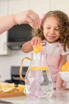 Little girl and mom squeezing lemon slices into pitcher San Francisco, California, United States CR_HOOX240731-1501862-01 ,model released, Symbolfoto ,property released