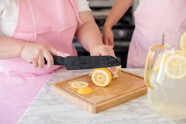 Mother slicing lemons on a cutting board in the kitchen for lemonade San Francisco, California, United States CR_HOOX240731-1501870-01 ,model released, Symbolfoto ,property released