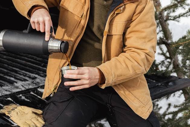 Man sitting on truck tailgate pouring hot coffee from a thermos Hanna, Utah, United States CR_XSQD2410148D-1562948-01 ,model released, Symbolfoto