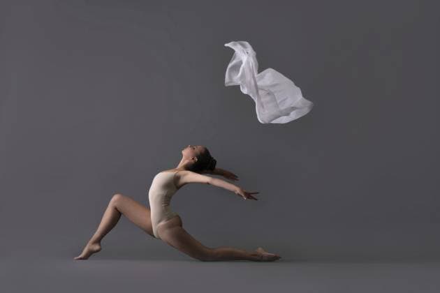 Anmutiges schlankes Mädchen in beigem Body wirft weißes Tuch hoch Profilansicht gegen graue Wand Graceful slim girl in beige body throwing white cloth up profile view against gray wall Copyright: imageBROKER AndreyxGuryanov ibxgur11555328.jpg ,model released, Symbolfoto ,property released