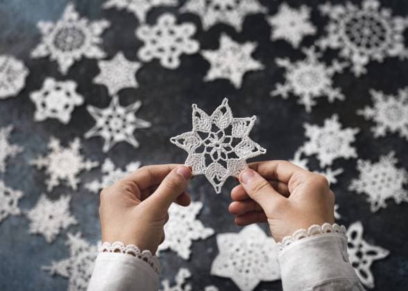 Eine gehäkelte Schneeflocke, Stern aus weißer Baumwolle in den Händen des Mädchen als kleines handgefertigtes Weihnachtsgeschenk oder Hausdekoration. Hobby und Handarbeit Konzept A crocheted snowflake, star made of white cotton in the girl s hands as a small handmade Christmas gift or home decoration. Hobby and handicraft concept Copyright: imageBROKER OksanaxSchmidt ibxoks11555615.jpg