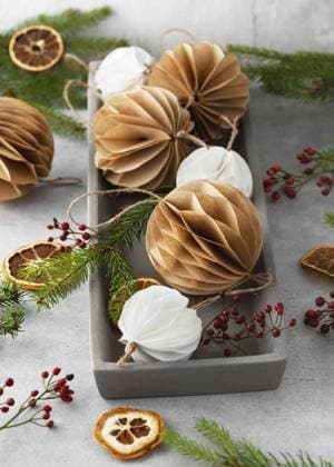 Rustikale Weihnachtsdekoration mit Papierornamenten, Tannenzweigen und getrockneten Orangen. Handgemachte Honigwaben Bälle aus weißem und braunem Kaffeefilter Papier. Skandinavisches Design Rustic Christmas decoration with paper ornaments, fir branches and dried oranges. Handmade honeycomb balls made from white and brown coffee filter paper. Scandinavian design Copyright: imageBROKER OksanaxSchmidt ibxoks11555627.jpg