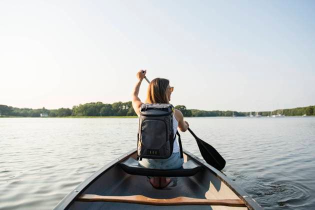 Woman with backpack paddling canoe on summer day Charlestown, Rhode Island, United States CR_CABR241016-1548131-01 ,model released, Symbolfoto