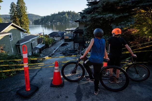 October 22, 2024, North Vancouver, Bc, CANADA: Two boys look at homes surrounded by debris left by flooding from torrential rain from an atmospheric river weather system at Deep Cove in North Vancouver, on Tuesday, October 22, 2024. North Vancouver CANADA  - ZUMAc35_ 20241022_zaf_c35_132 Copyright: xEthanxCairnsx