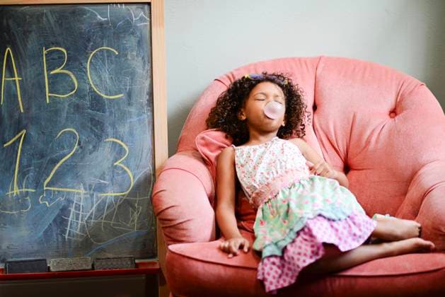 Creative Highlights Symbolfotos Young girl relaxing on a pink chair, blowing a bubble with bubbl United States, Florida, Inverness CR_YWQX241014-1556234-01 ,model released, Symbolfoto