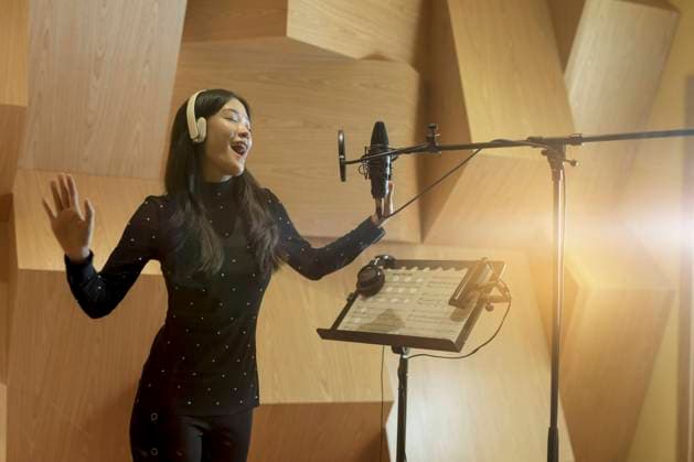 Cheerful young singer wearing wireless headphones and recording song in studio model released, Symbolfoto property released, EAF00307