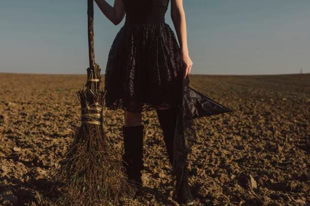 Woman standing with broom on field at Halloween model released, Symbolfoto, VSNF02565