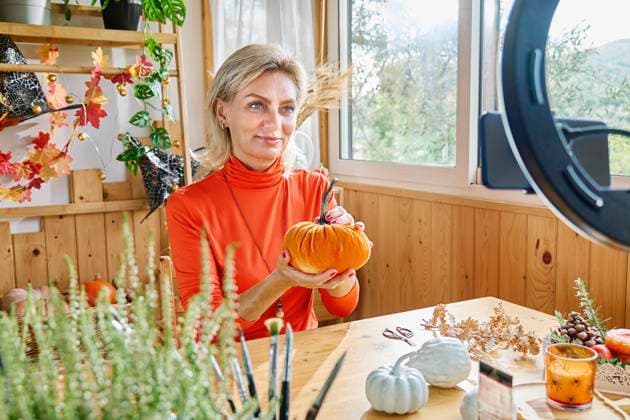 Blond mature woman showing DIY pumpkin and vlogging through smart phone at home model released, Symbolfoto property released, CATF00406