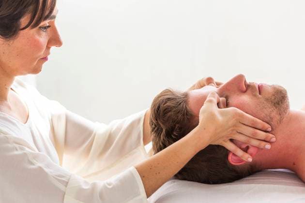 Therapist giving head massage to man in spa model released, Symbolfoto, MEGF01019