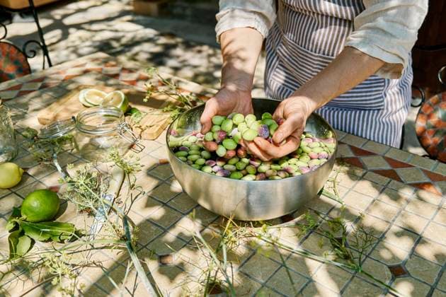 Mature woman washing olives in big metal bowl model released, Symbolfoto property released, CATF00444