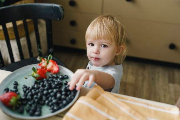 Girl having blueberries at table in kitchen model released, Symbolfoto property released, VBUF00594