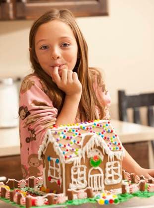 Portrait of girl (6-7) licking finger by gingerbread house , 03.03.2011, model released, TTBB_ti3602017.jpg, Eating,Licking Finger,Gingerbread House,Christmas,Portrait,Pajamas,Childhood,Traditional Culture,Food And Drink,Looking At Camera,One Girl Only,USA,Utah,Vertical,Indoors,Day,Smiling,Waist Up,6-7 Years,Caucasian Ethnicity,One Person,Lehi Copyright: xMikexKempx