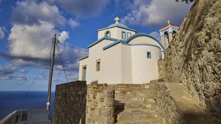 Sankt Filimon Kirche, Kirche auf einem Steinwall mit blau weißen Farbakzenten unter Wolken, Farbenfrohes Bergdorf, Morgenlicht, Olymbos, Karpathos, Dodekanes, Griechische Inseln, Griechenland, Europa Saint Filimon Church, Church on a stone wall with blue and white colour accents under clouds, Colourful mountain village, Morning light, Olymbos, Karpathos, Dodecanese, Greek Islands, Greece, Europe Copyright: imageBROKER RalfxAdler ibxraa11641230.jpg