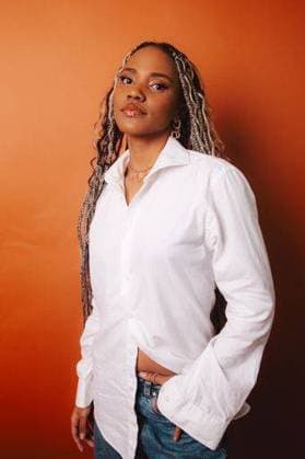 Creative Highlights Symbolfotos A stylish South African woman with long braids posing against an orange backdrop 25664990 ,model released, Symbolfoto RECORD DATE NOT STATED