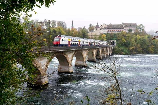 Train passing over the Rheinbrücke bei Laufen bridge at the beautiful Swiss Rhine Falls, seen during the fall time. Schaffhausen *** Train passing over the Rheinbrücke bei Laufen bridge at the beautiful Swiss Rhine Falls, seen during the fall time Schaffhausen