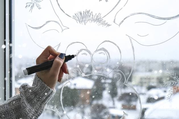 Weibliche Handmalerei Weihnachtshirsch auf Fensterglas gemalt. Weihnachten Winter Dekor auf dem Fensterglas. Weißes Muster von Hirschen. Schnee Kunst Maßwerk Fenster auf Urlaub Saison. Basteln. Hygge Zuhause Female hand painting Christmas deer painted on window glass. Christmas winter decor on the window glass. White pattern of deer. Snow art tracery window on holiday season. Diy. Hygge home Copyright: imageBROKER AnastasiiaxYanishevs ibxiqx11312584.jpg