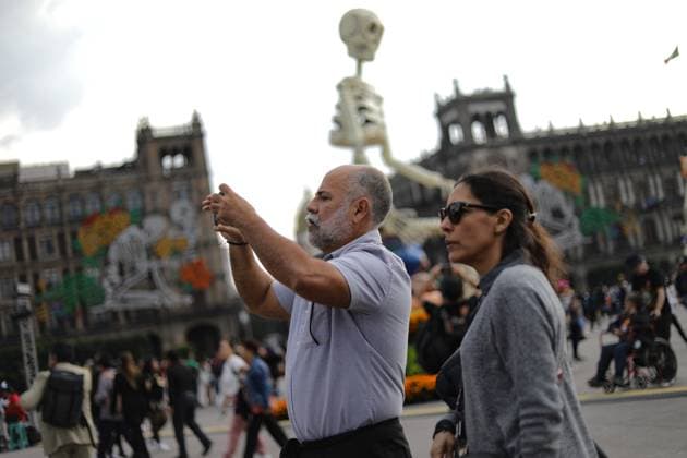 A person taking photos of the Mega Ofrenda featuring monumental cardboard skeletons at the main square Zocalo as part of the Mexican Dia de Muertos festivities. on October 31, 2024 in Mexico City, Mexico. Mexico City Mexico - ZUMAe321 20241031_zia_e321_054 Copyright: xIanxRoblesx