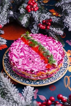 Festlicher Hering unter einem Pelzmantel mit lebhaftem Belag Traditional russian layered salad herring under a fur coat with beetroot, served alongside holiday decor Copyright: xZoonar.com AntonxDobreax 22281964