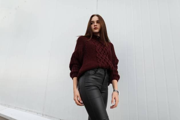 Attraktive junge Frau in einem modischen Strickpullover in stilvollem Leder schwarze Hose posiert in der Nähe eines modernen weißen wallin der Stadt.Cute europäisches Mädchen Mode-Modell steht auf der Straße in der Nähe des Gebäudes *** attractive Boy Woman in a fashionable Knitted sweater in stylish Leather Black Pants poses in the Proximity one modern white Wallin the City cute European Girls Fashion Model is at the Street in the Proximity of Building 1102811797 ,model released, Symbolfoto