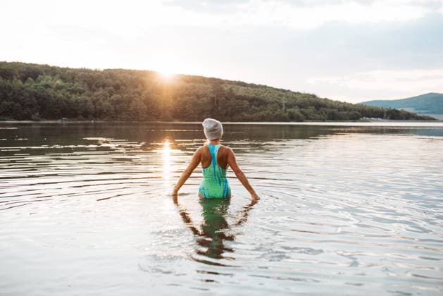 IMAGO Creative, Winter, Auf dem Land Cold water swimming for elderly women. Senior sporty women standing in lake during cold evening, looking at setting sun. Cold water swimming for elderly women. Senior sporty women standing in lake during cold evening, looking at setting sun model released