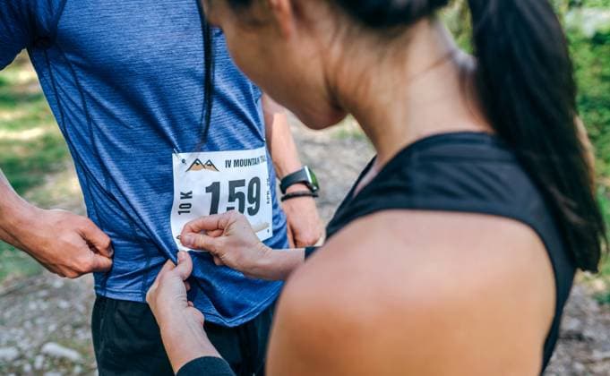 Creative Highlights Symbolfotos Trail athlete placing race number to her partner Young female trail athlete placing race number to her partner Model Released DavidPereiras_ID24880_720573_014 Copyright: xDavidxPereirasx