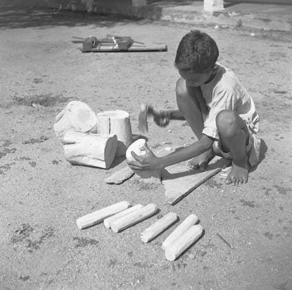 Young boy using portable rotating lathe applying lacquer wringtinforia wood ; painting lacquer toys ; Channapatna ; Karnataka Copyright: xTxSatyan DinodiaxPhotox