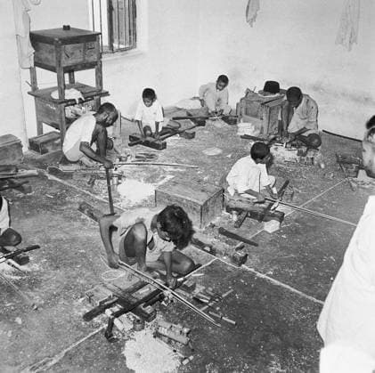 Young boys using portable rotating lathe applying lacquer wringtinforia wood ; painting lacquer toys ; Channapatna ; Karnataka Copyright: xTxSatyan DinodiaxPhotox
