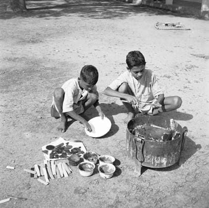 Boys using portable rotating lathe ; applying lacquer wood wringtinforia ; painting lacquer toys ; Channapatna ; Karnataka Copyright: xTxSatyan DinodiaxPhotox