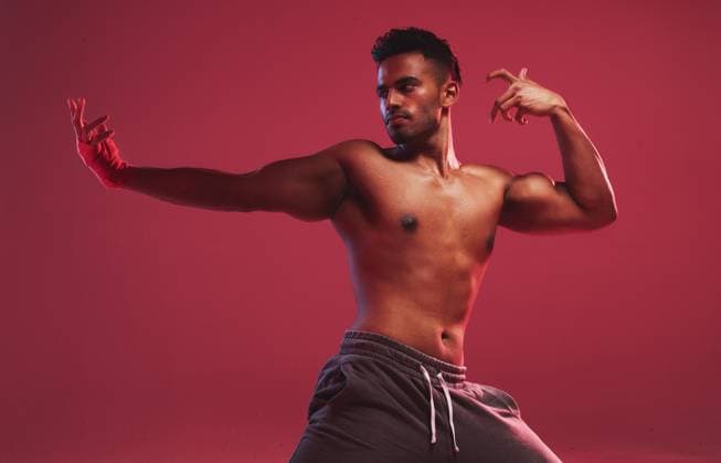 Creative Highlights Symbolfotos Man, martial arts and studio with fitness, action and ready for fight training by red background. Person, athlete or shirtless with combat sports, workout and exercise with muscle, wellness or health. model released property released Copyright: xwww.peopleimages.comx