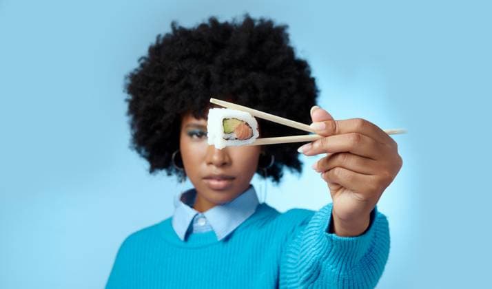 Creative Highlights Symbolfotos Food, studio and black woman with sushi in a portrait eating a Japanese diet with mockup space alone. Healthy, mock up and hungry African girl with an afro holding seafood with asian chopsticks. model released property released Copyright: xwww.peopleimages.comx