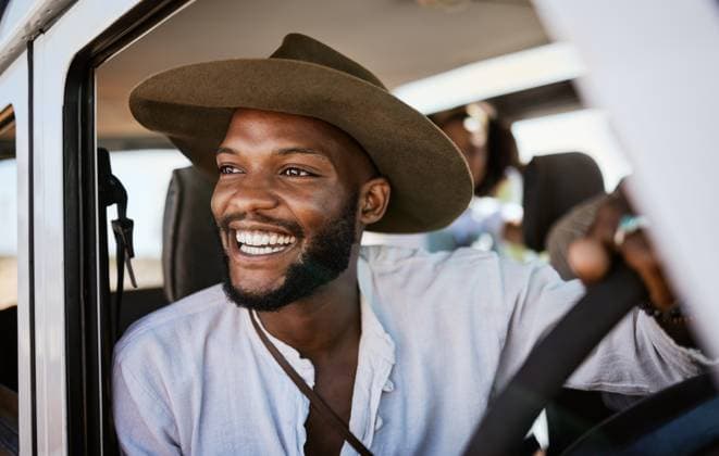 Creative Highlights Symbolfotos Happy, taxi and driver with black man driving and enjoying career, safari tour guide in vehicle. Adventure, travel and smile african american looking excited while touring with passenger, carefree. model released property released Copyright: xwww.peopleimages.comx