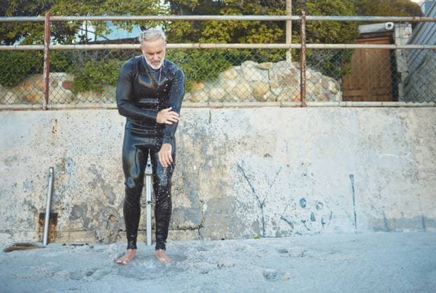 Creative Highlights Symbolfotos Senior man, surfer and beach sand of a person after a surfing exercise and summer fitness in nature. Sports and water workout of a elderly athlete finished with a cardio and strong surf session. model released property released Copyright: xwww.peopleimages.comx