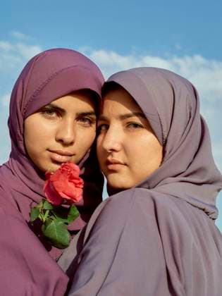 Creative Highlights Symbolbilder Two women wearing purple hijabs pose with a rose against a blue sky, Morocco bola04305 Copyright: xConnectxImagesx ,model released