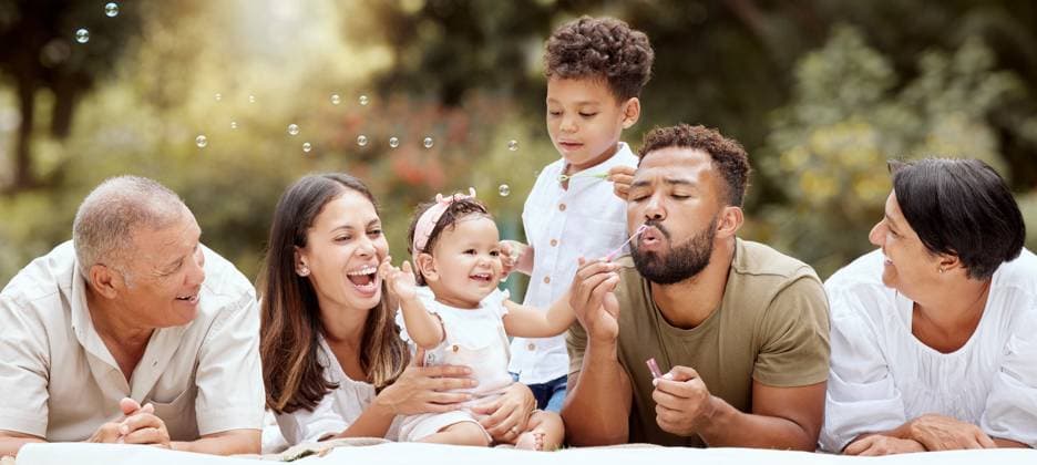 Happy, smile and big family blowing bubbles in a garden on a summer picnic in Puerto Rico. Happiness, grandparents and parents with children playing, having fun and relaxing together in the park. model released property released Copyright: xPeopleImages.comx-x 2535749x