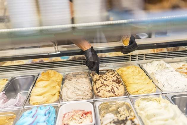 Unerkennbare Hände eines Arbeiters, der Eis von der Theke eines Ladens nimmt Unrecognizable hands of a worker picking ice cream from counter of a store Copyright: imageBROKER UnaixHuizi ibxuhu11665264.jpg ,model released, Symbolfoto ,property released