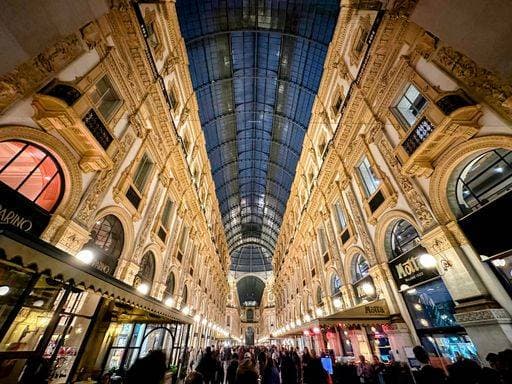 A vibrant evening view of Galleria Vittorio Emanuele II in Milan, Italy, showcasing its stunning architecture and bustling atmosphere. 26984210