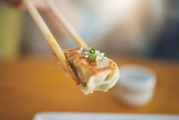 IMAGO Creative, Food, Dumplings Closeup, protein and chopsticks with dumpling at a restaurant for food, Asian culture or fine dining. Health, hungry and person with dinner, eating lunch or enjoying a fried dish or cuisine at a cafe. model released property released Copyright: xwww.peopleimages.comx