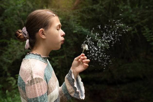 Creative Highlights Symbolbilder Young teen girl blowing dandelion seeds outdoors in lush forest Norman, Oklahoma, United States CR_AOVS241112A-1577581-01 ,model released, Symbolfoto